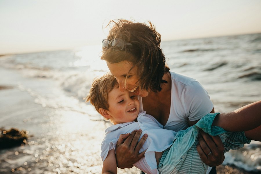 Mãe abraçando o filho na praia